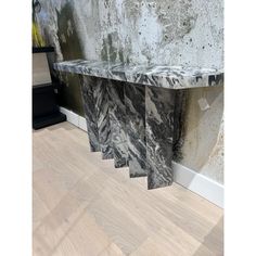 a marble shelf sitting on top of a hard wood floor