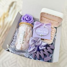 an open box with some items in it and a purple ribbon around the bow tie