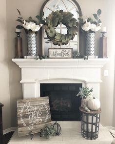 a fireplace mantel decorated with white flowers and greenery