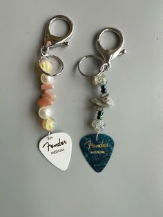 two keychains with charms attached to them that say fenderer and the words,