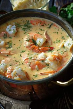 a pot filled with shrimp and grits on top of a table