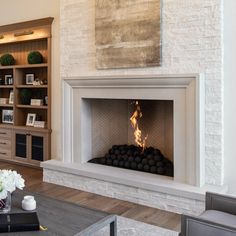 a living room with a fire place in the center and bookshelves behind it