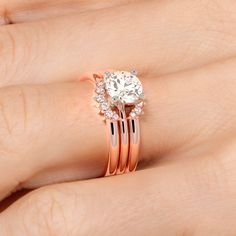 a woman's hand with two rings on it and a diamond ring in the middle