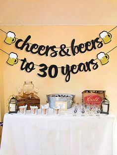 a table topped with lots of bottles and glasses next to a sign that says cheers to 30 years