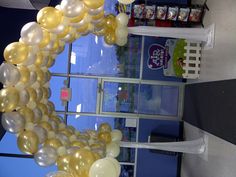 an entrance decorated with gold and white balloons