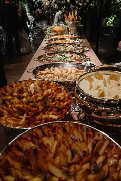 a buffet table filled with lots of different types of food on top of metal pans