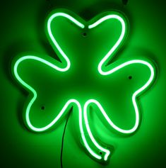 a green neon sign with a four leaf clover