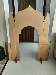 an arch made out of cardboard sitting on the floor