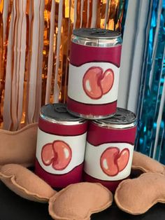 three red and white canisters sitting on top of a table next to pillows