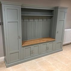 an empty room with gray cabinets and wooden bench