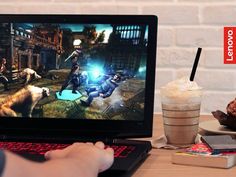 a person is playing an interactive video game on their laptop computer while eating ice cream and drinking coffee