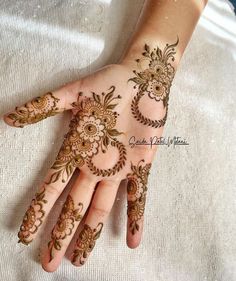 a woman's hand with hennap on it and flowers painted on the palm