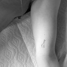 a small giraffe tattoo on the left arm and foot is shown in black and white