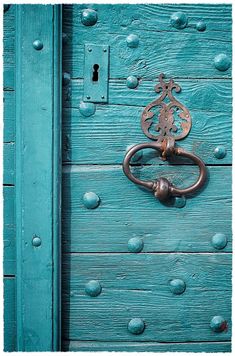 an old blue door with a metal handle on it