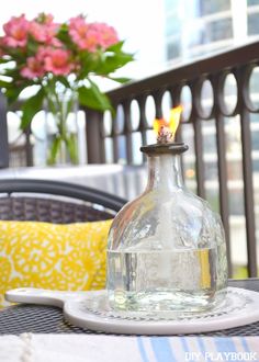 a glass bottle sitting on top of a table next to a plate with a candle in it