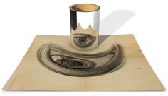 a drawing of an eye in the middle of a piece of wood on top of a table