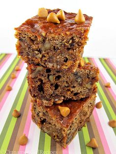 three pieces of cake stacked on top of each other with nuts and chocolate chips all over them