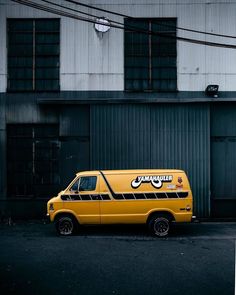 a yellow van parked in front of a building