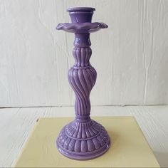 a purple candle holder sitting on top of a table