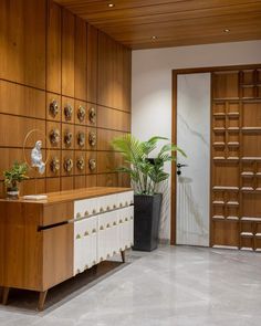 a room with wooden paneled walls and white marble flooring that has a plant on top of it