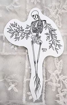 a sticker with a skeleton on it sitting on top of a lace tablecloth