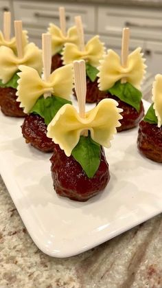 small appetizers are arranged on a plate with toothpicks in the shape of flowers