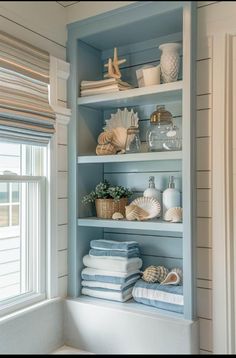 the shelves are filled with towels and seashells