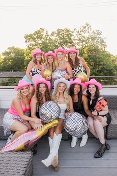 a group of women in costumes posing for a photo with disco balls on their heads