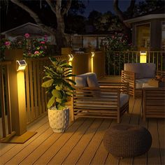 an outdoor deck lit up with lights and furniture