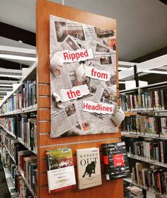 newspapers are taped to the side of a book shelf in a library filled with books