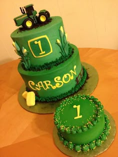 two cakes decorated with green frosting on top of a wooden table