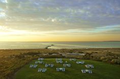 an aerial view of lawn chairs and the ocean in the background at sunset or sunrise