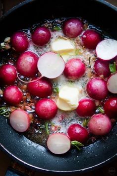 radishes are being cooked in a pan with water and butter on the side