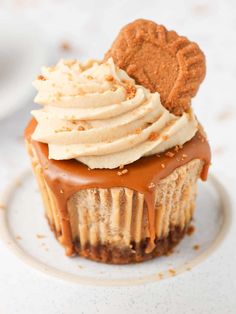 a cupcake topped with frosting and a heart shaped cookie on top of it