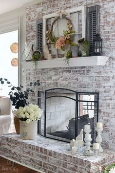 a brick fireplace with flowers and candles on it