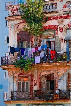 an old building with clothes hanging out to dry on the balcony and balconies