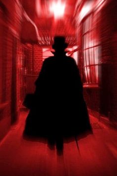 a man in a hat and coat walking down a hallway with red light coming from the ceiling