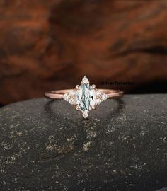 a white diamond ring sitting on top of a rock