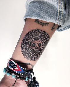 a person's arm with a tattoo on it and a skull in the center