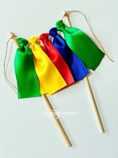 three wooden sticks with different colored bags on top of each other, tied together and ready to be used as an ornament