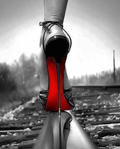 a woman's feet with high heels on train tracks in black and white photo