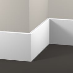 an empty corner in a room with gray walls and white trim on the wall is shown