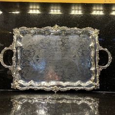 an ornate silver tray sitting on top of a black counter