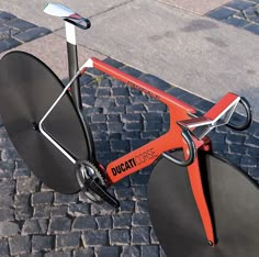 an orange and black bicycle parked on the street