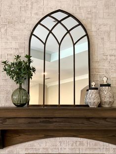 a fireplace mantle with a mirror and vases on it