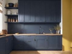 a kitchen with blue cabinets and yellow walls in the corner, along with wooden flooring