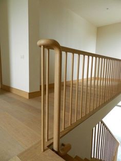 an empty room with wooden railings and hard wood flooring