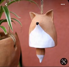 an ornament shaped like a fox hanging from a plant