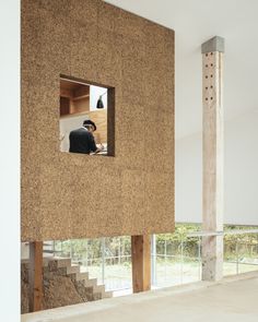 a man sitting at a desk in the middle of a room that is made out of cork