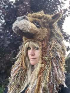 a woman wearing a knitted animal hat with dreadlocks on it's head